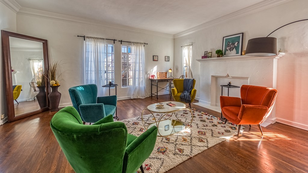 a living room with chairs and a rug and a fireplace