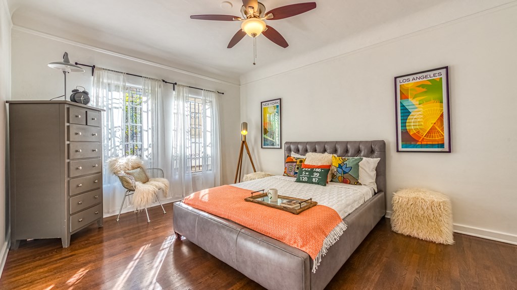 a bedroom with a bed and a ceiling fan