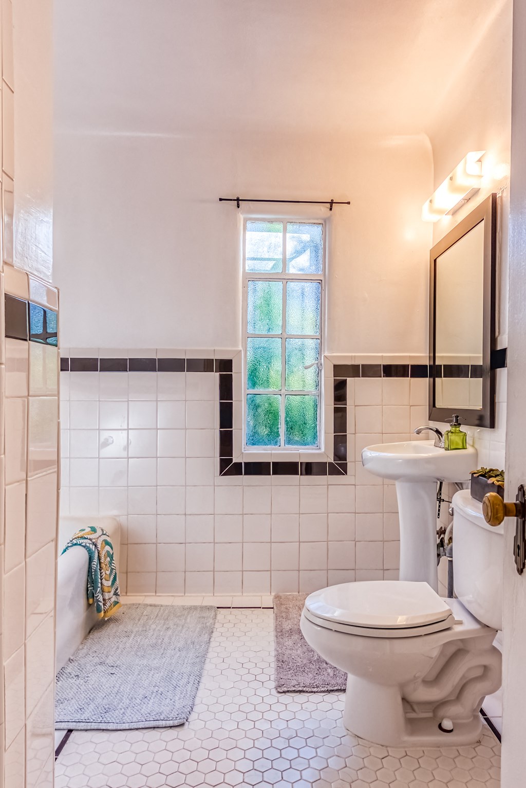 a bathroom with a toilet and a sink and a window