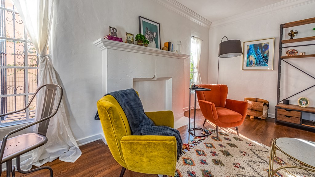 a living room with yellow chairs and a fireplace     and a table