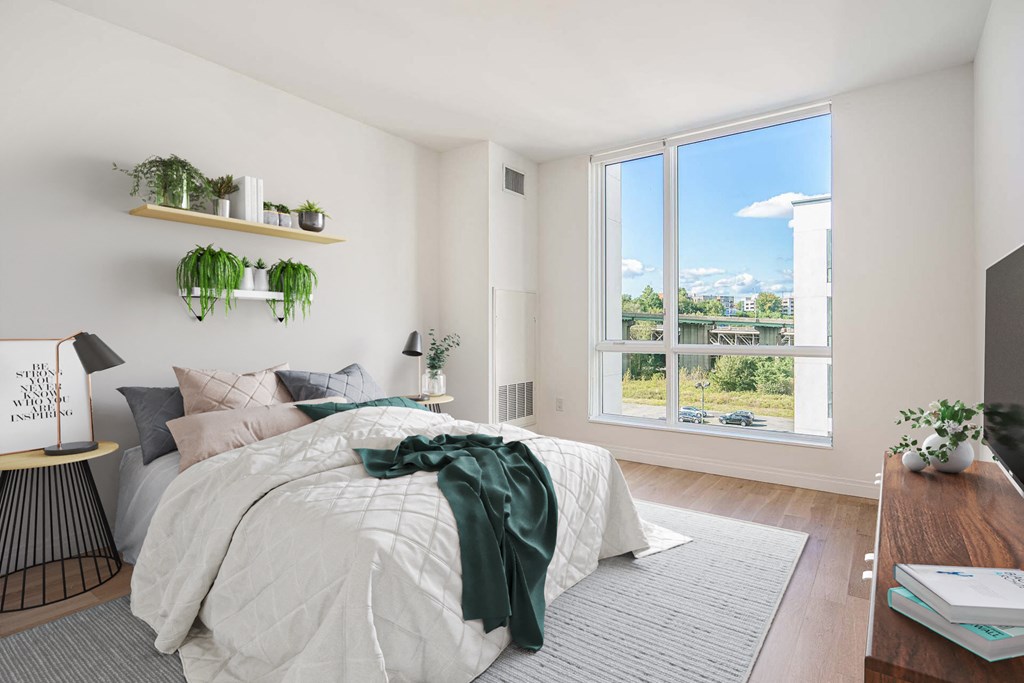 a bedroom with a bed and a large window