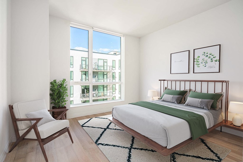 a bedroom with a bed and a large window