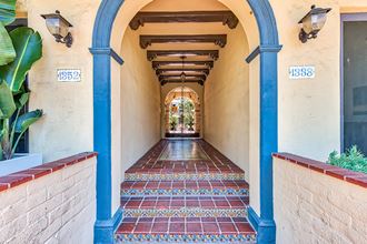 a long hallway with blue archways and tiles on the floor