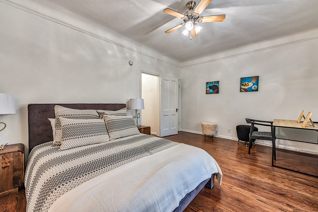 a bedroom with a large bed and a ceiling fan