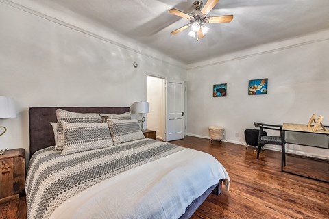 a bedroom with a large bed and a ceiling fan