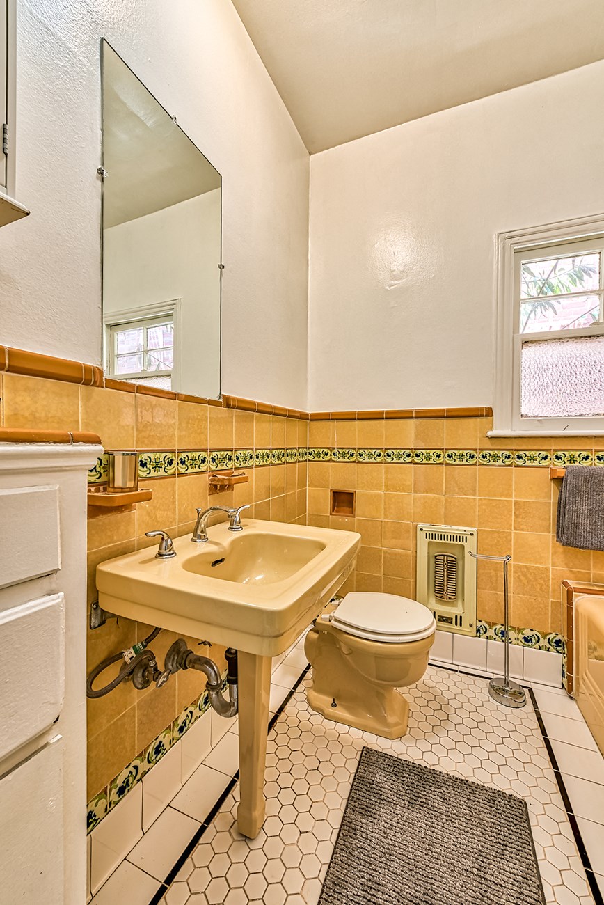 a bathroom with a toilet and a sink and a mirror