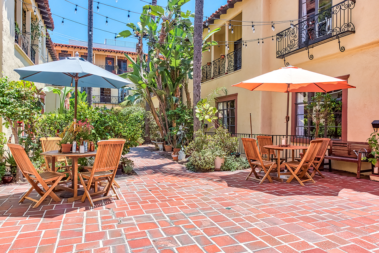 a patio with tables and chairs and umbrellas