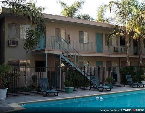 an apartment building with a swimming pool and palm trees