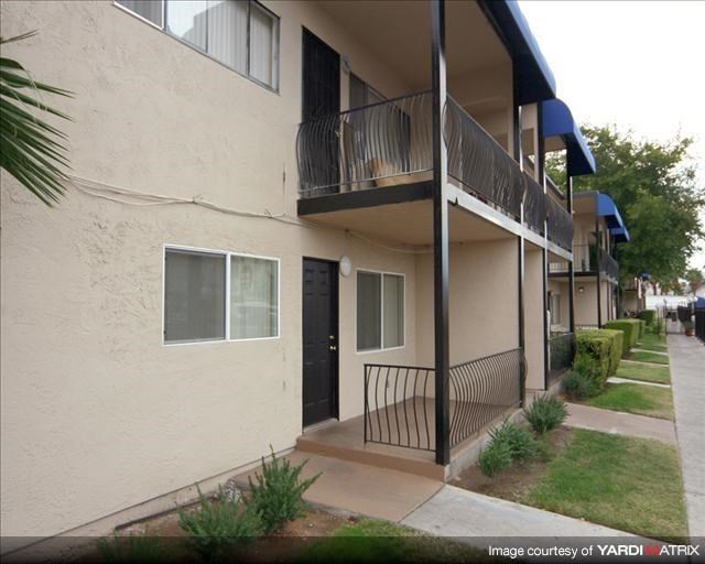 an apartment building with a balcony and a black door