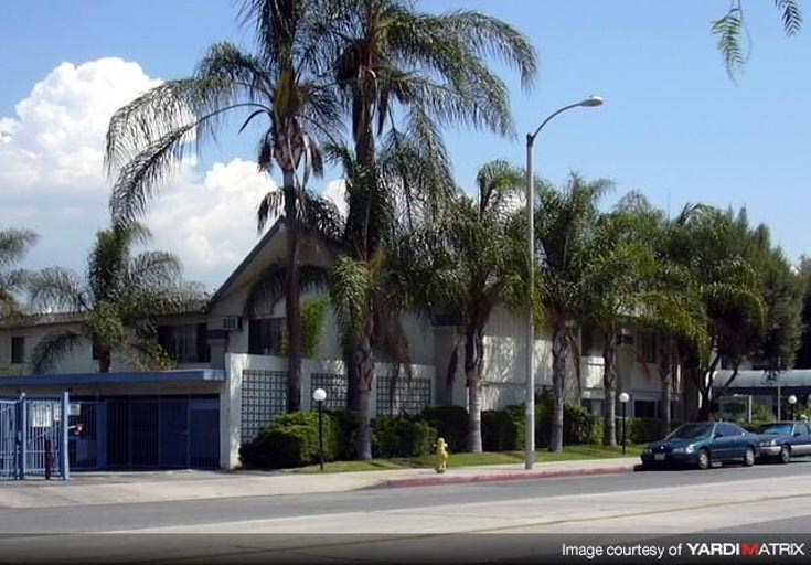 a car parked in front of a building with palm trees