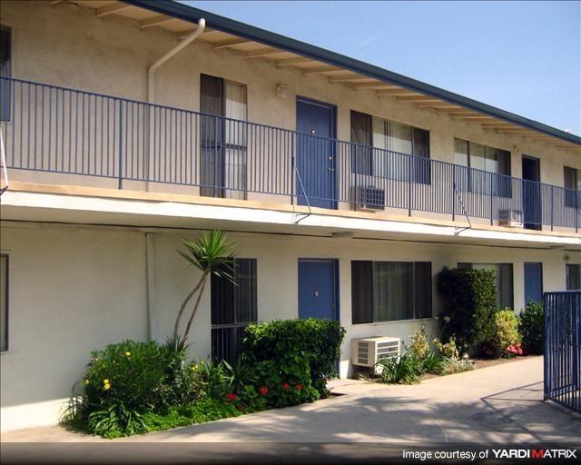 an apartment building with a balcony and a courtyard