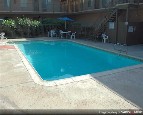a blue swimming pool in front of a building