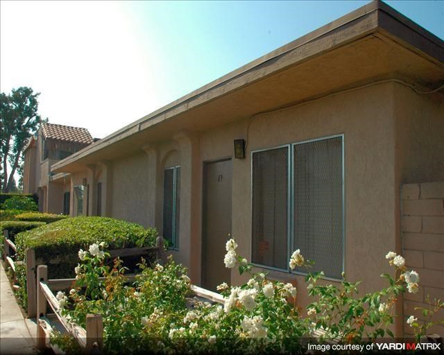 a row of houses with bushes and flowers