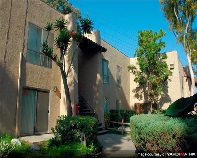 an apartment building with a courtyard and trees