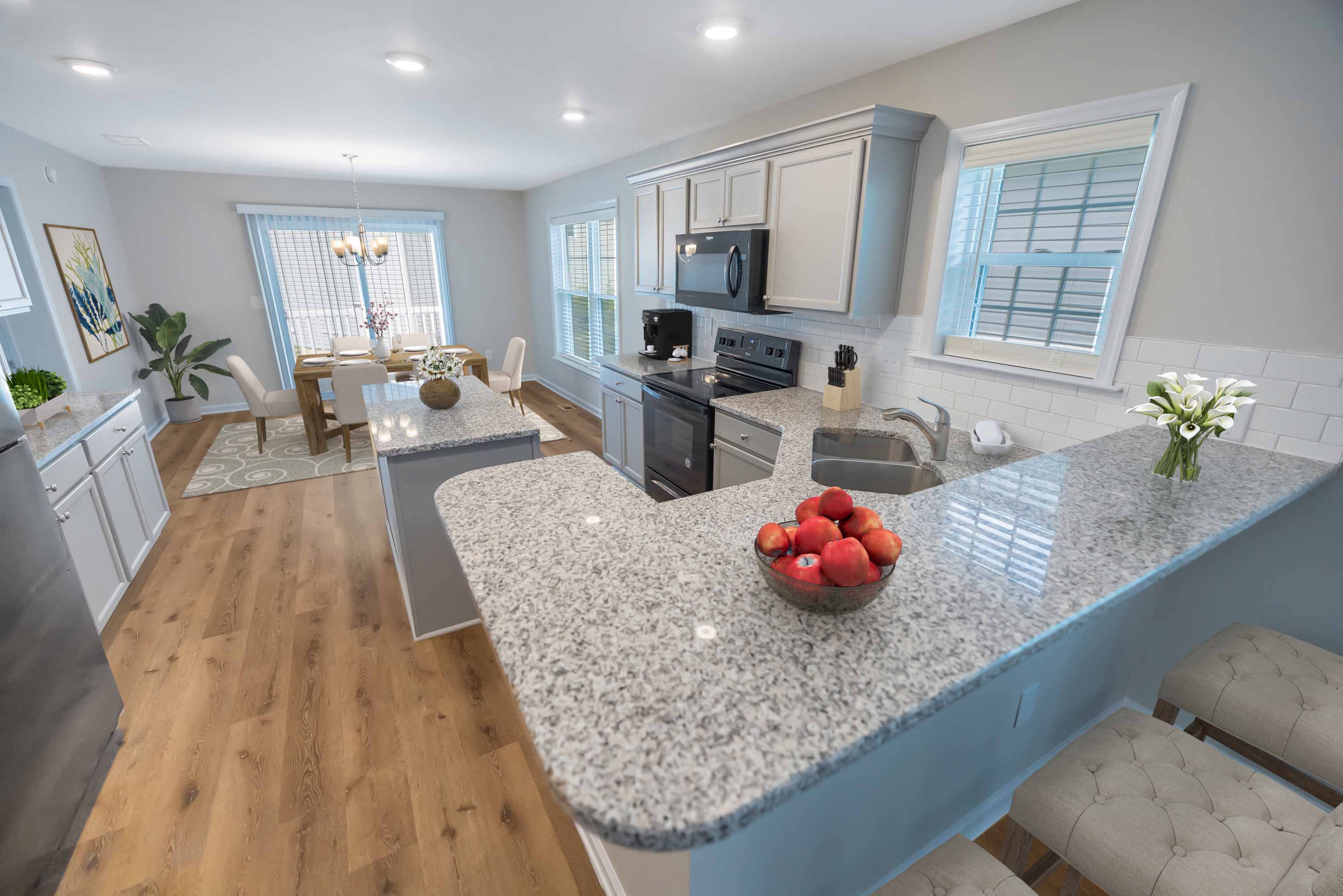 an open kitchen and living room with a granite counter top