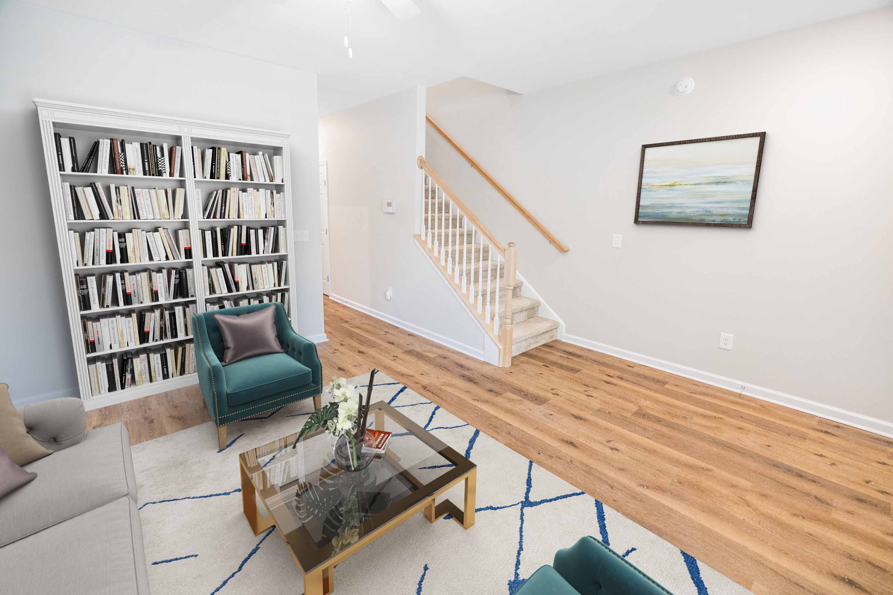 a living room with a staircase and a book shelf