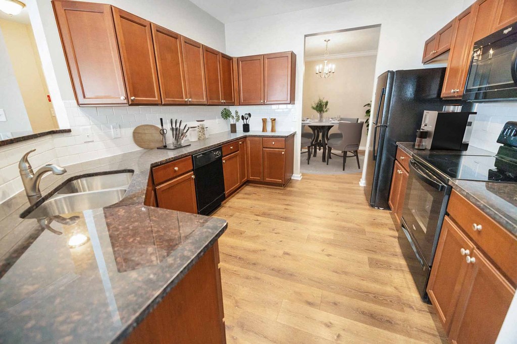 a large kitchen with wooden cabinets and black appliances