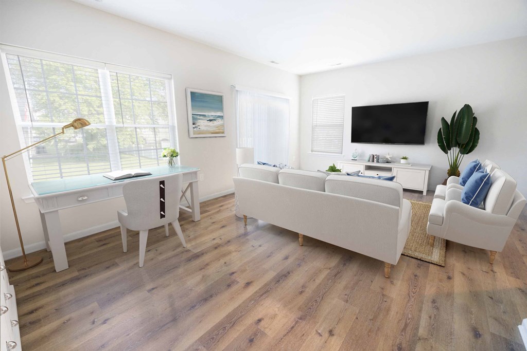 a living room with white furniture and a tv