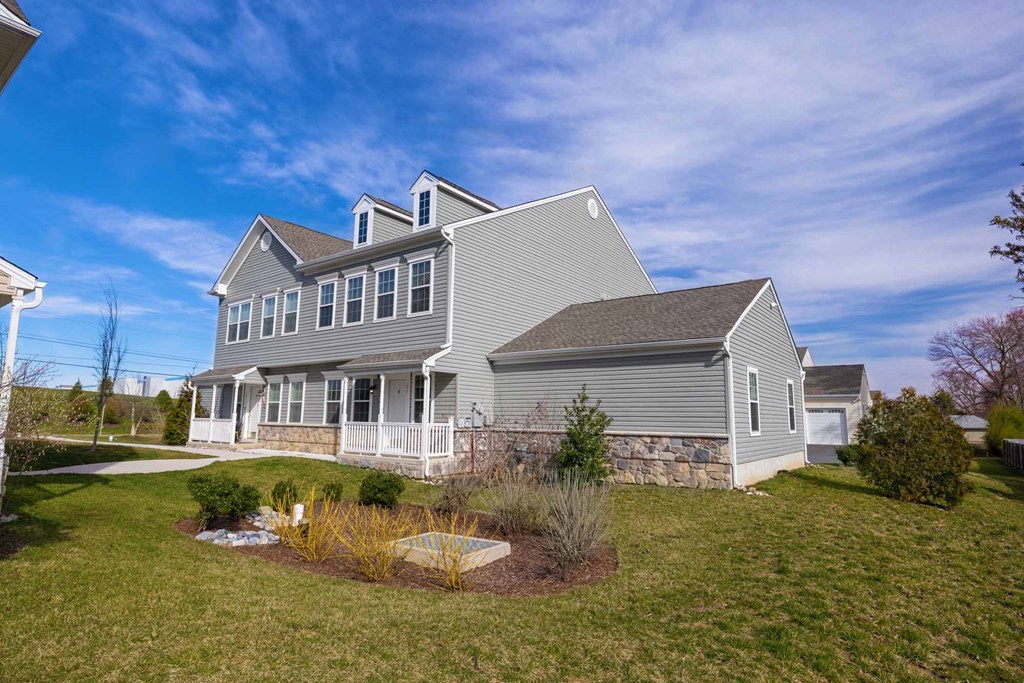 a gray house with a yard and a blue sky