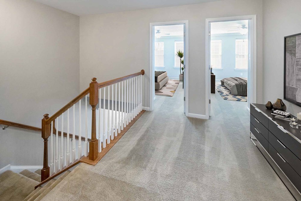 a living room with a staircase and a door to a bedroom