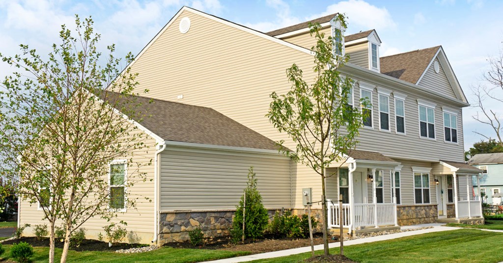 the front of a house with trees and a sidewalk