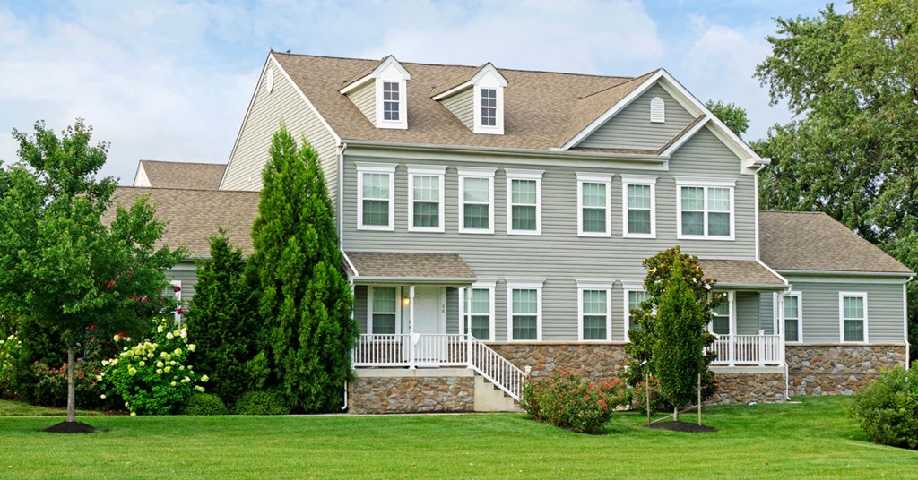 a large house with a lawn and trees in front of it