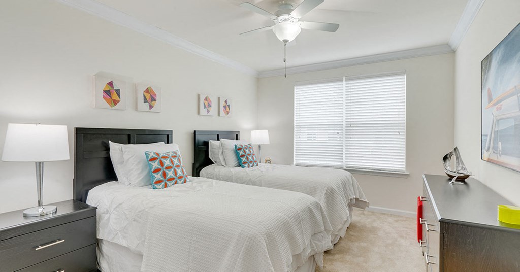 a bedroom with two beds and a ceiling fan