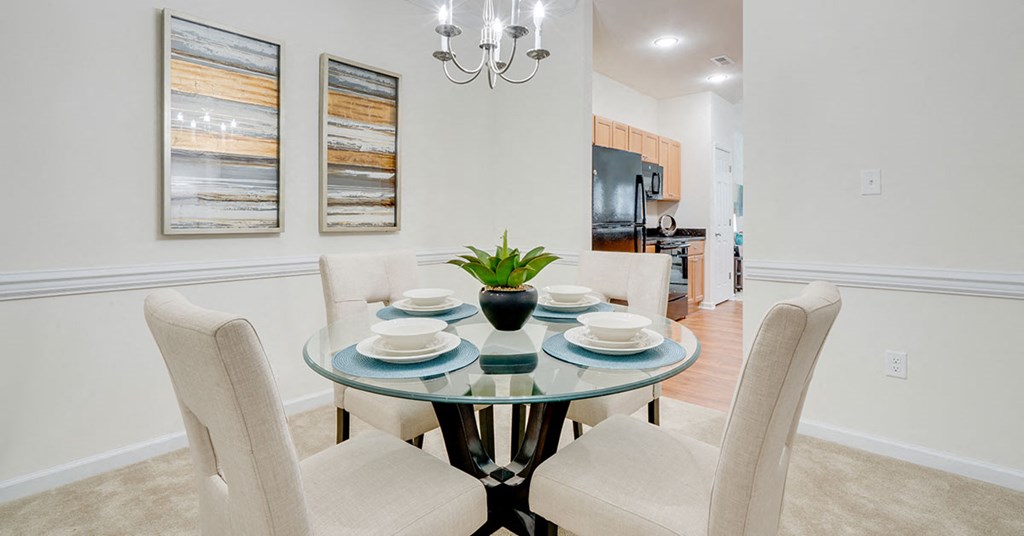 a dining room with a glass table and chairs