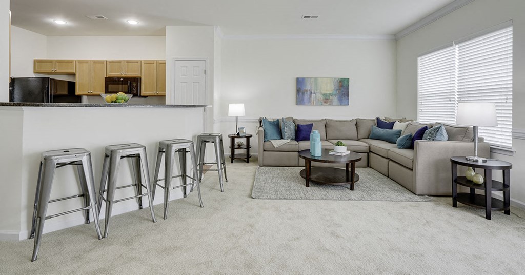 a living room with a couch and a bar with stools