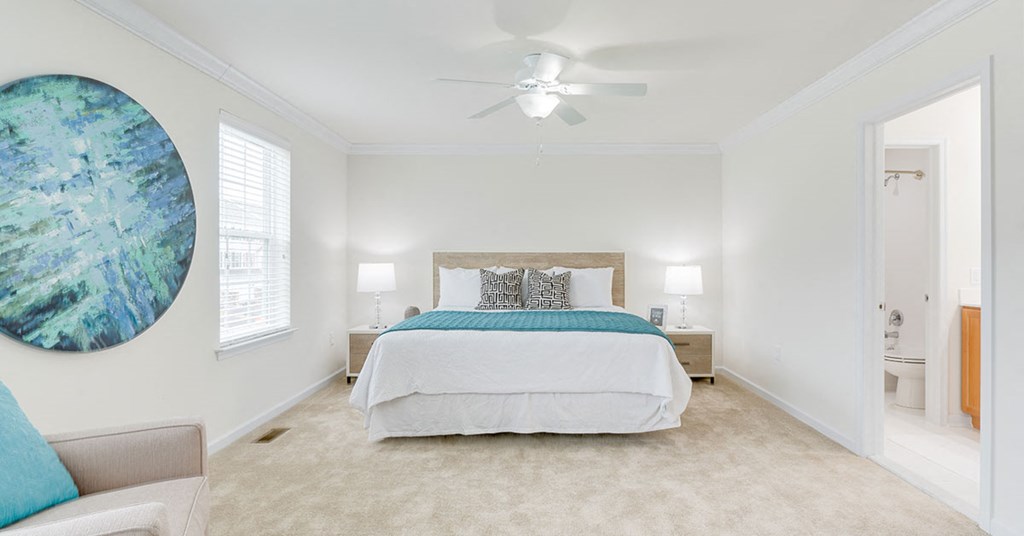 a bedroom with a bed and a ceiling fan