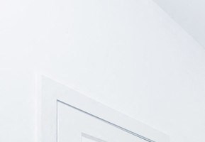 Bedroom model with carpeted floors and white walls, double windows and walk-in closet