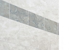 Bathroom with wooden cabinets and light grey tiles and white walls