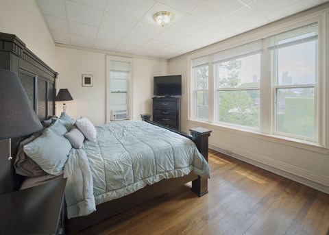 a bedroom with a bed and three windows