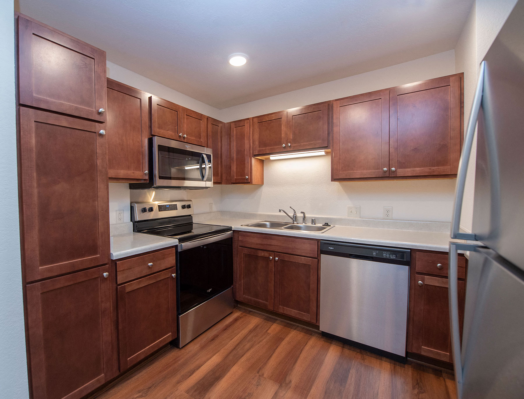 full kitchen with wood cabinets and stainless steel appliances at the reserve at south coast apartments