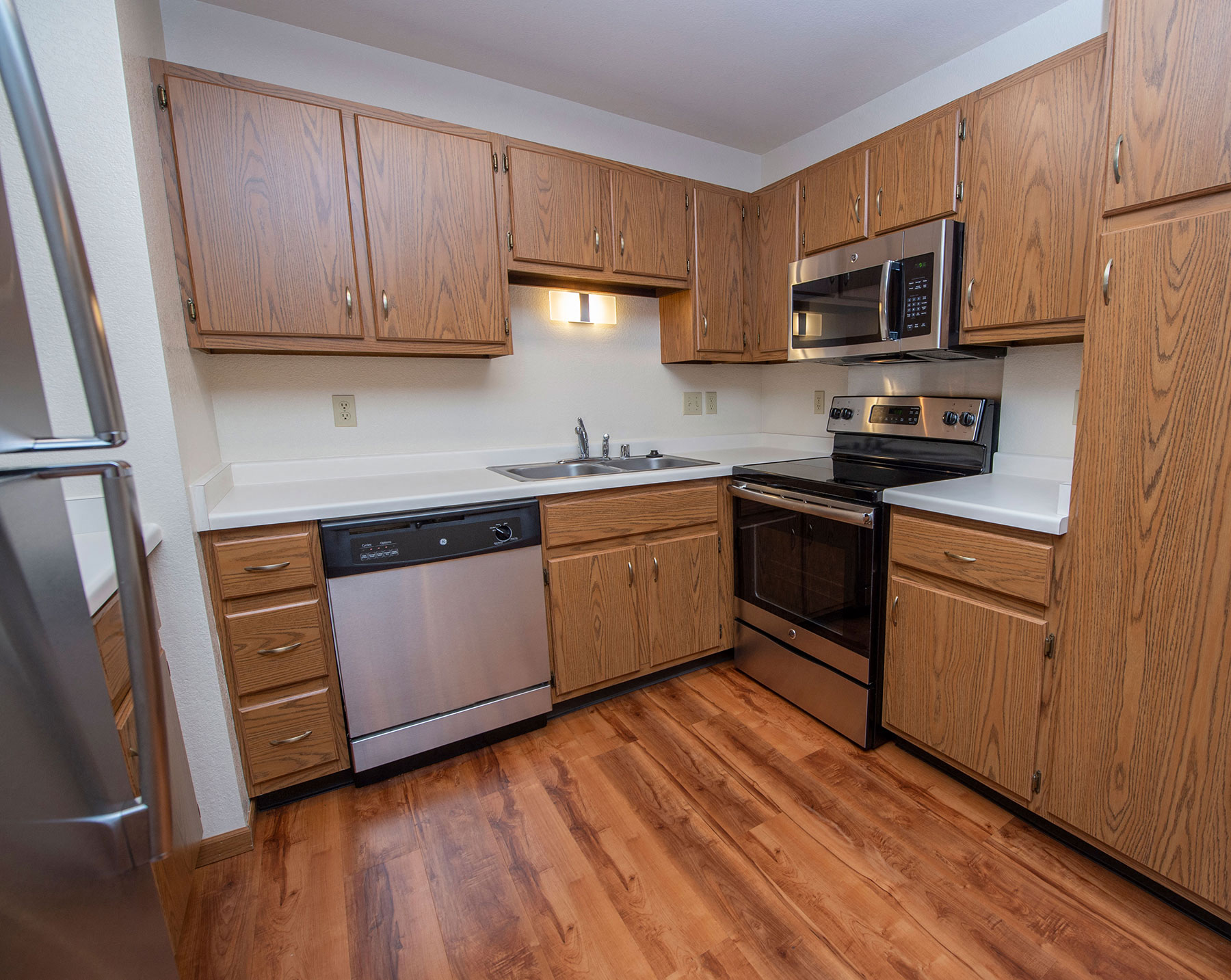 an empty kitchen with wooden cabinets and stainless steel appliances