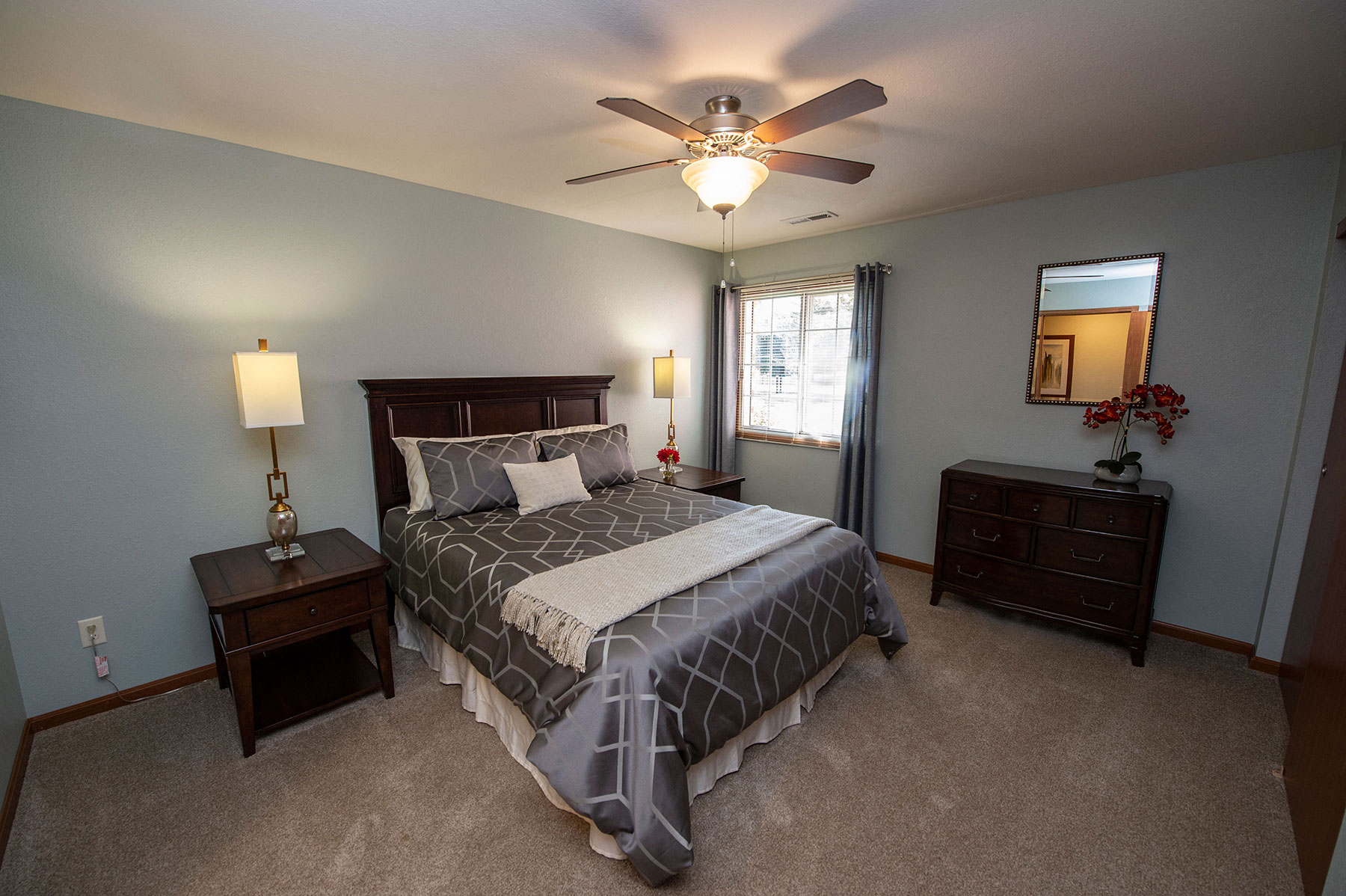 a bedroom with a bed and a ceiling fan