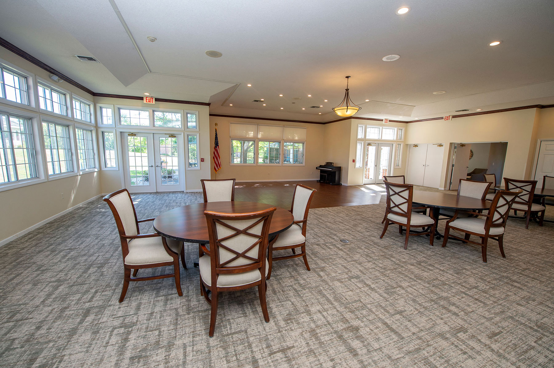 a dining room with a table and chairs in a room with large windows
