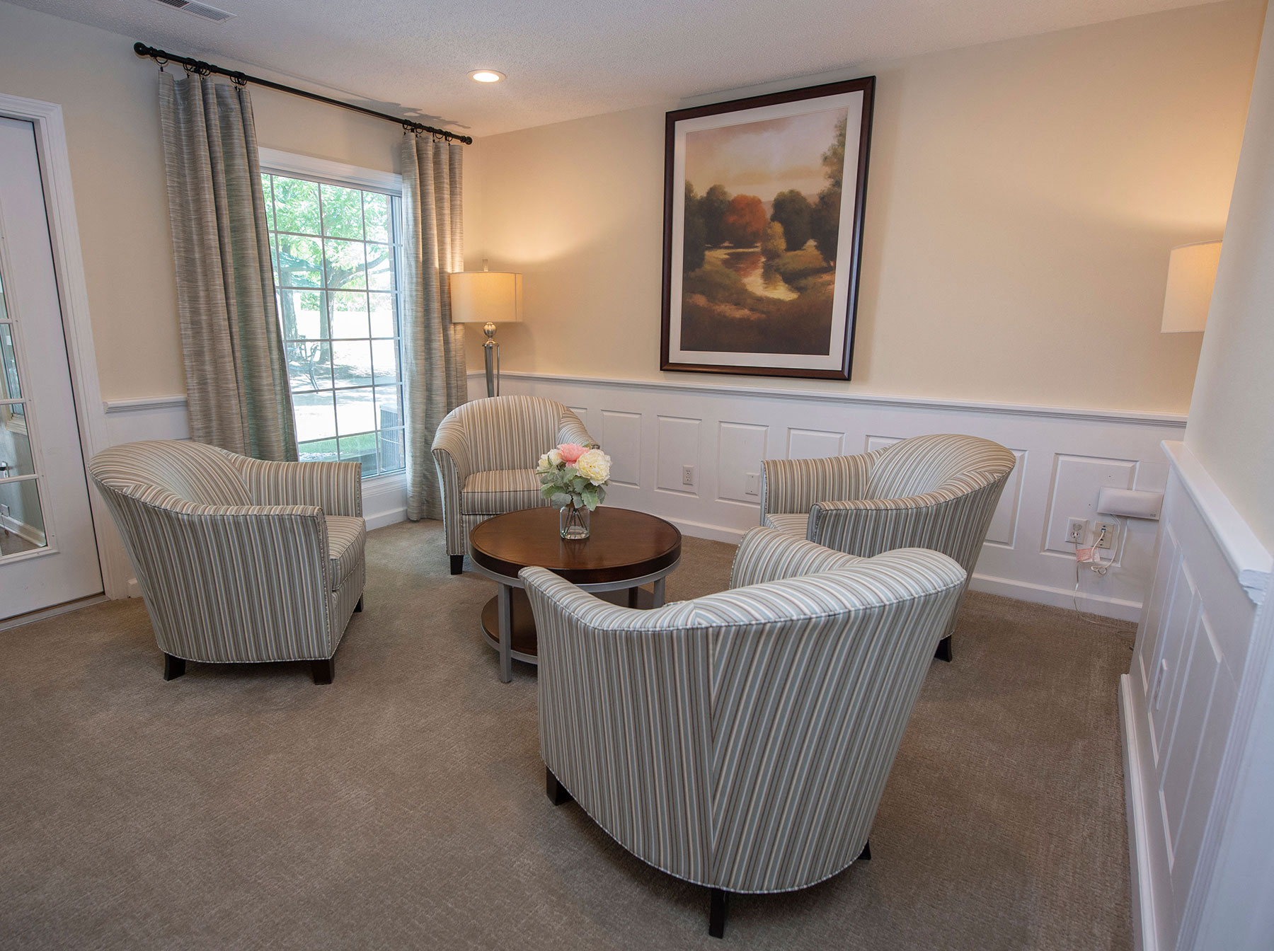 a living room with striped chairs and a coffee table