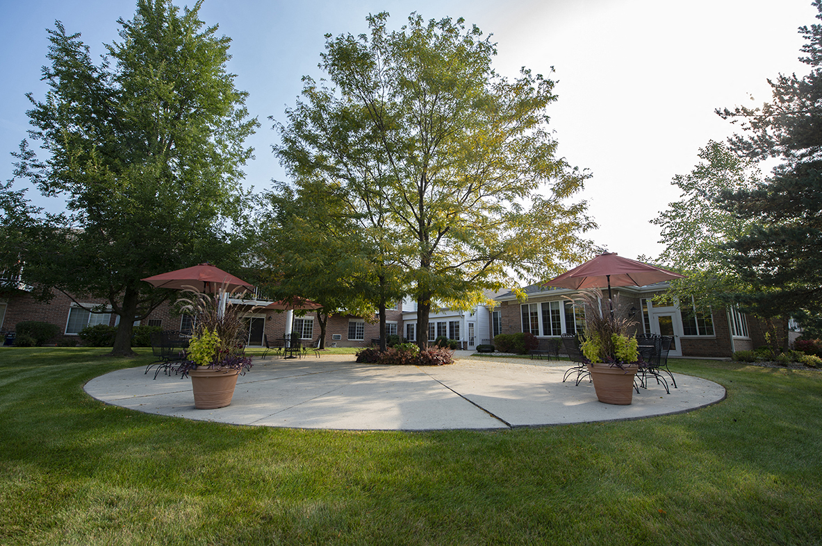a large patio in front of a house with umbrellas
