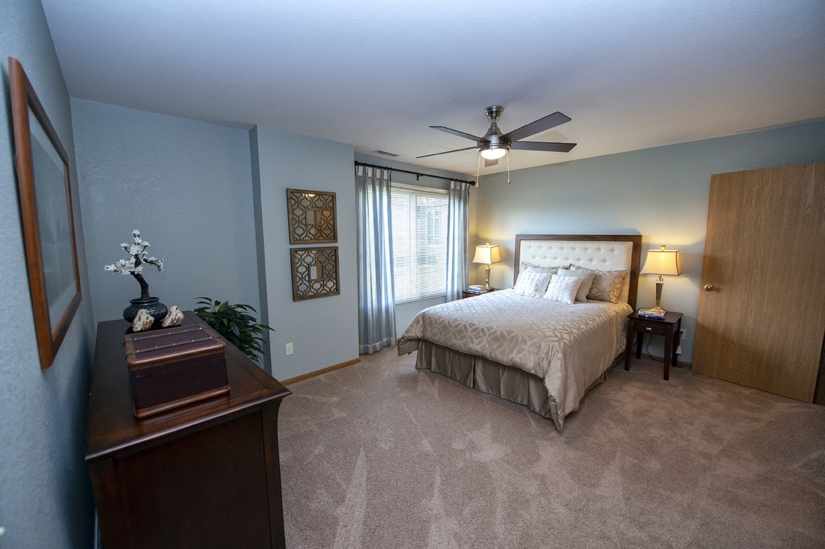 a bedroom with a bed and a ceiling fan
