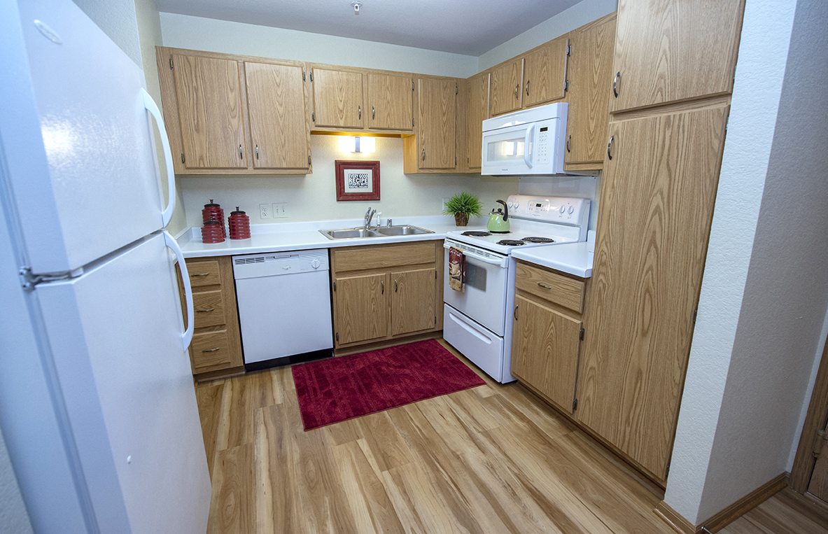a kitchen with white appliances and wooden cabinets