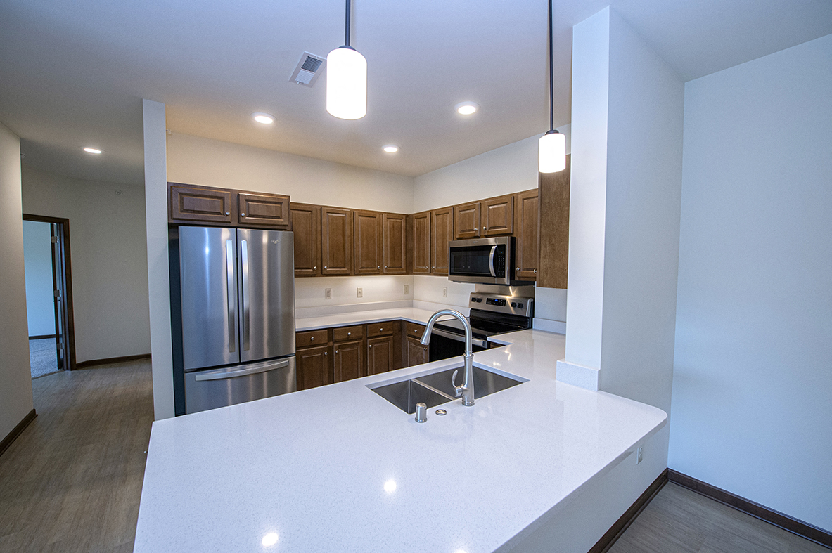 a kitchen with stainless steel appliances and white counter tops
