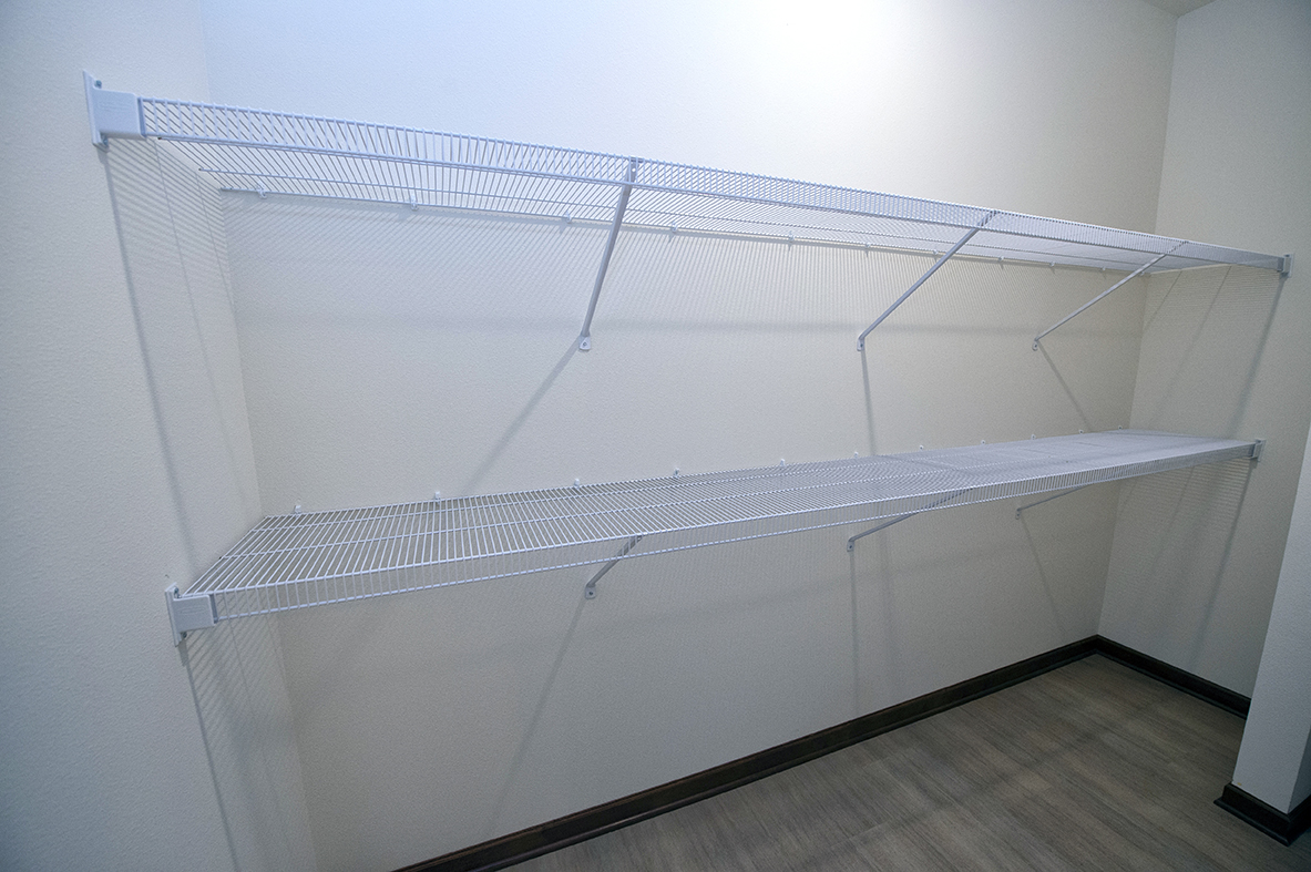 a large white closet with empty shelves in a room