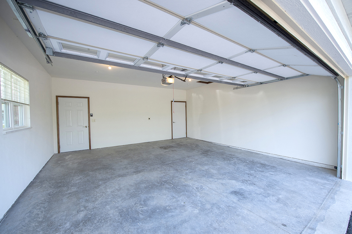 the interior of a garage with a concrete floor and white walls