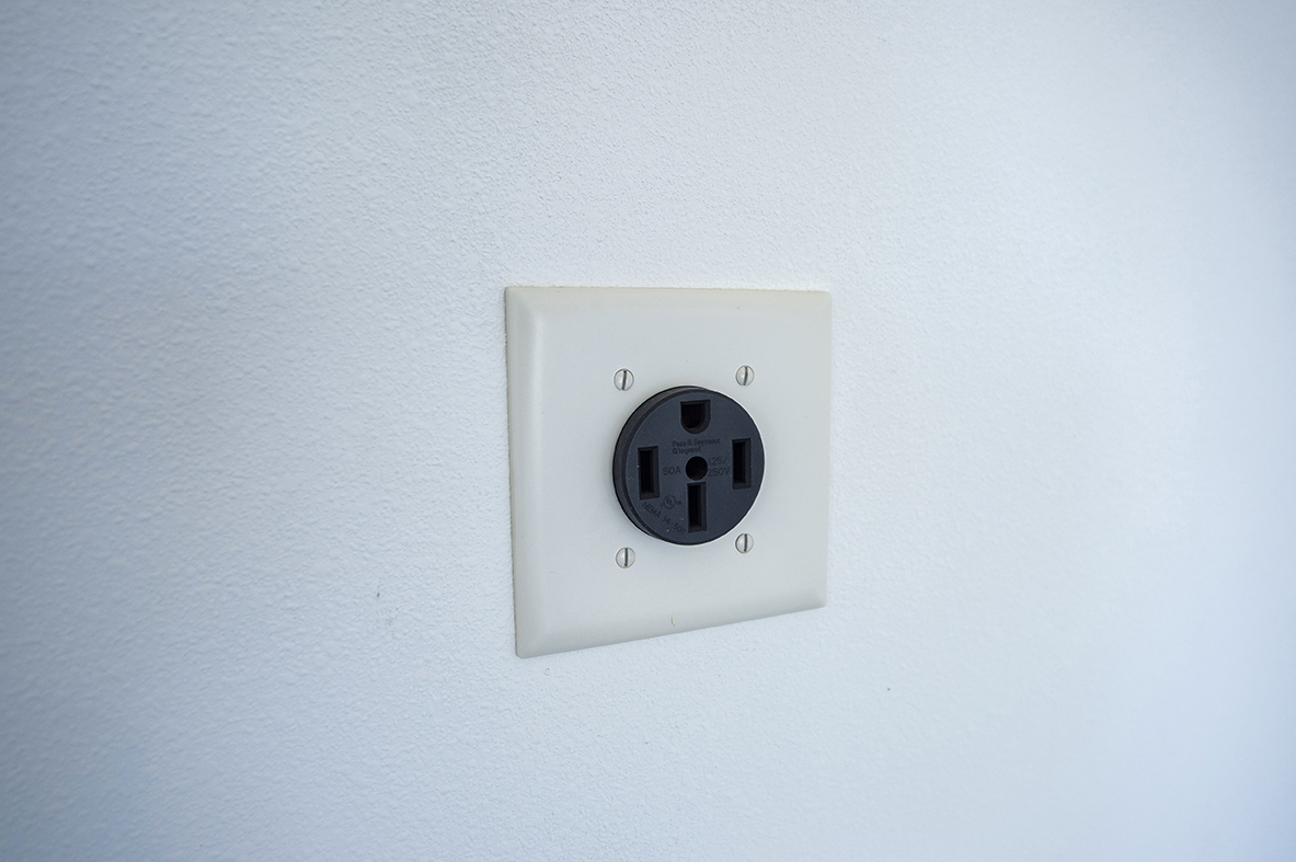 a white light switch on a white wall