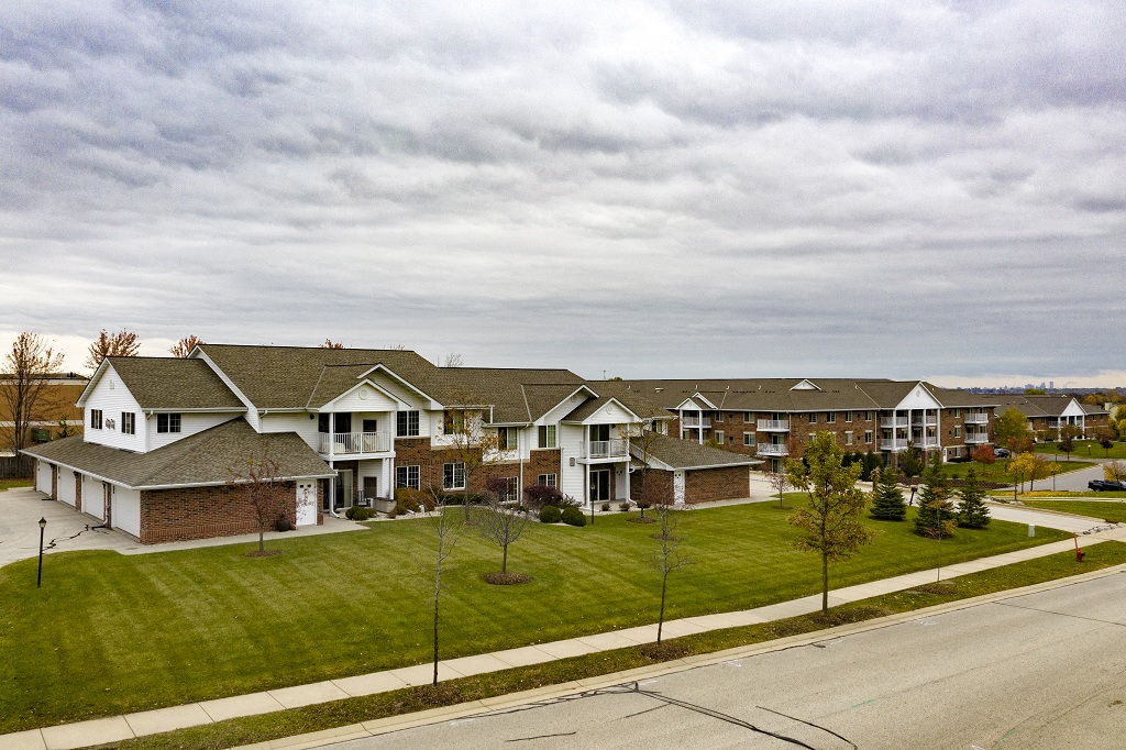 a row of houses on a green lawn next to a street