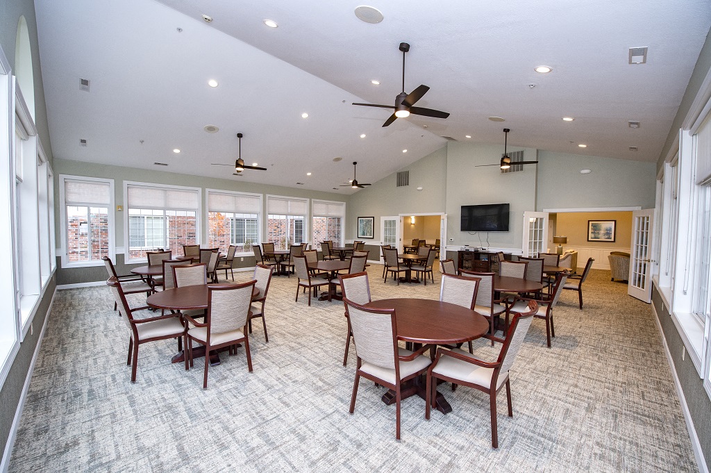 a large dining room with tables and chairs and a tv