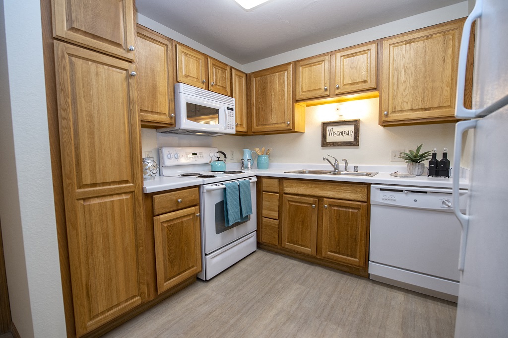 a kitchen with white appliances and wooden cabinets