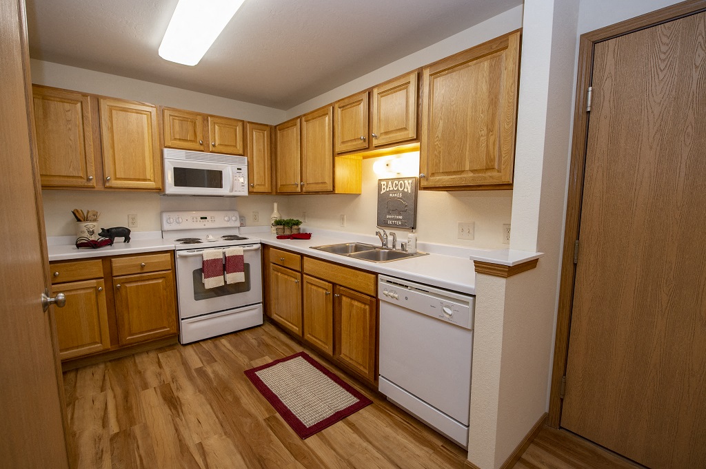 a kitchen with white appliances and wooden cabinets