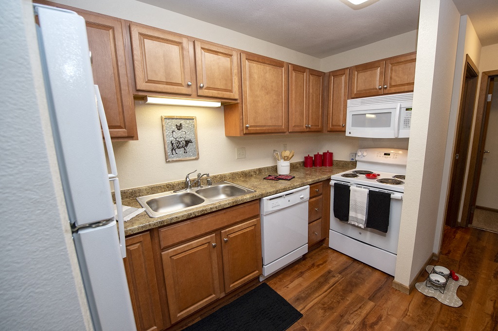 a kitchen with white appliances and wooden cabinets